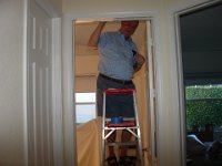 Dad At Work  Dad putting a border of blue tape around the baby's room before he paints